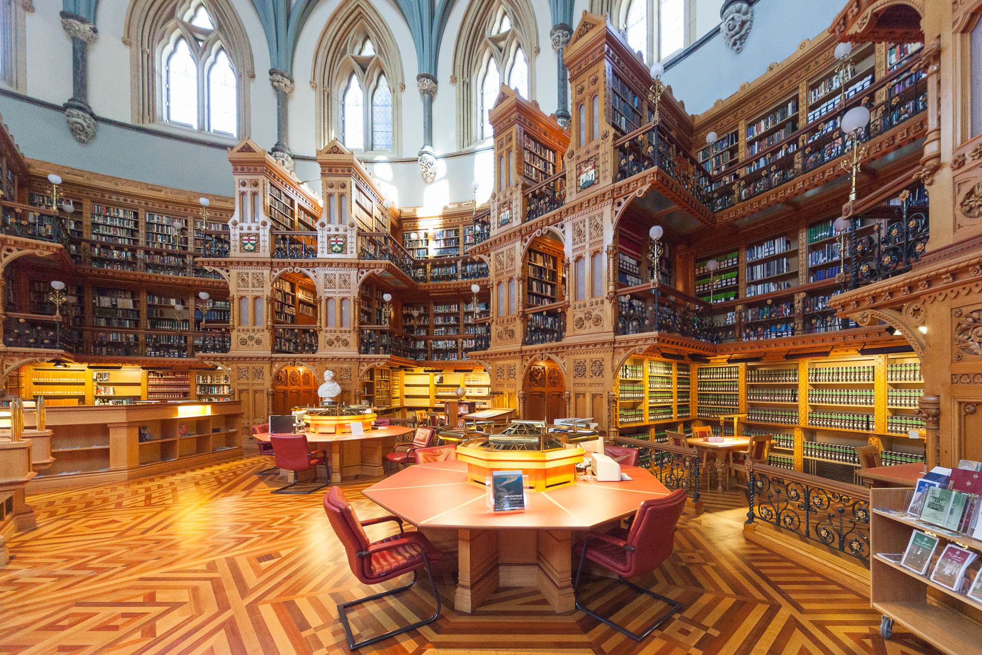Image of the Library of Parliament in Canada, a neogothic building with tall wooden bookshelves.