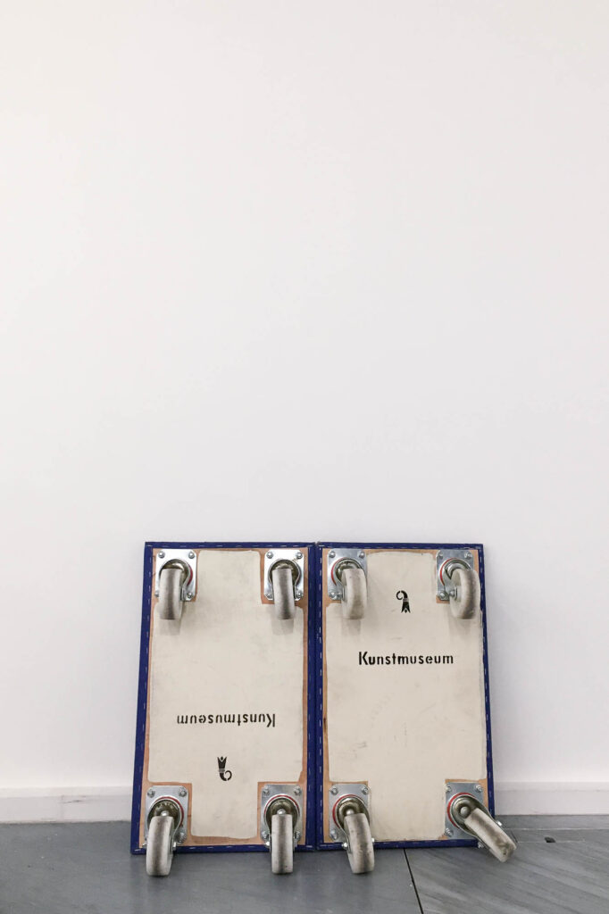 Two carts are set against a wall. The words "Kunstmuseum" (art museum) are written on them.