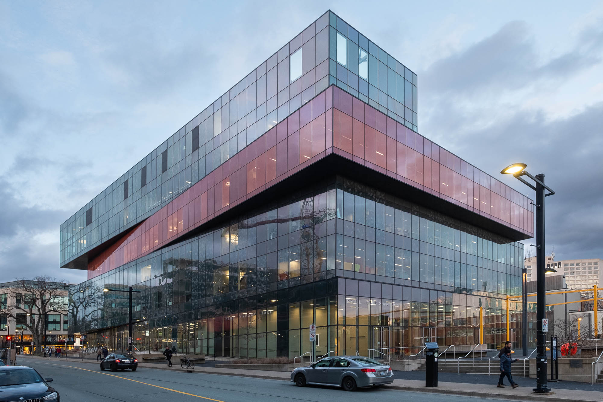 Exterior of a contemporary library at nightfall. Each level is slightly offset from the others, resembling a stack of boxes.