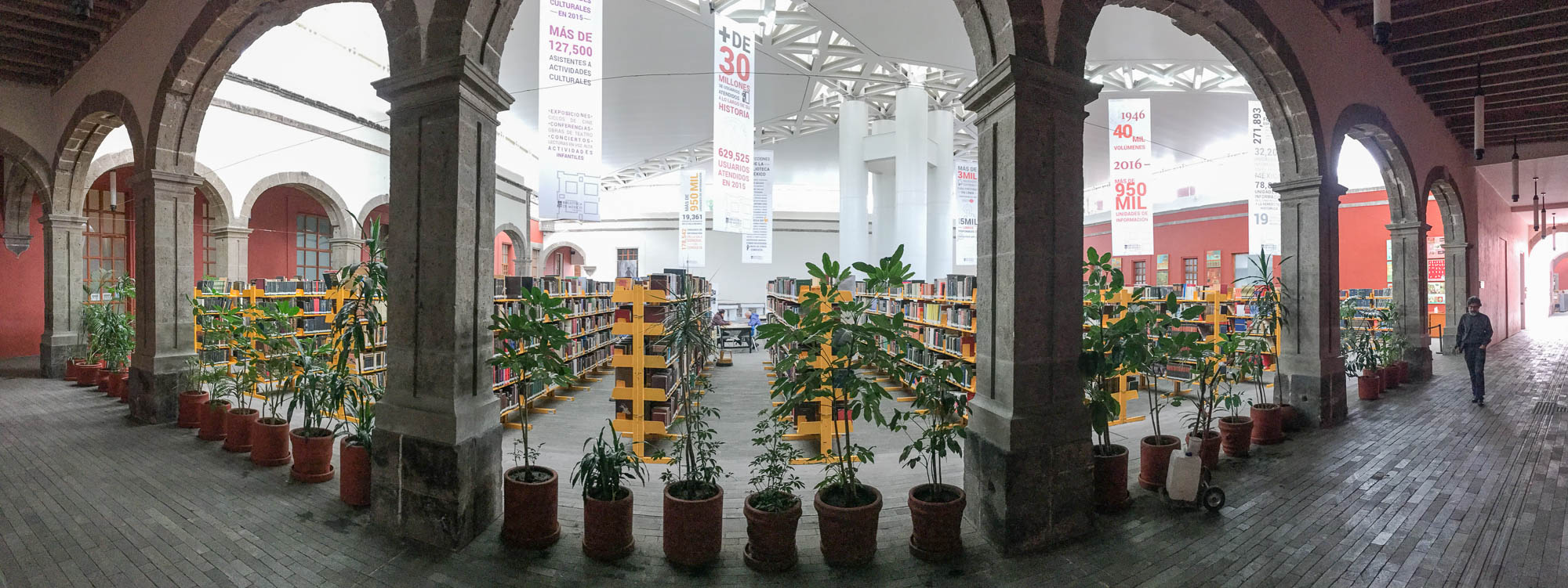 Panoramic shot of a courtyard with bookshelves.