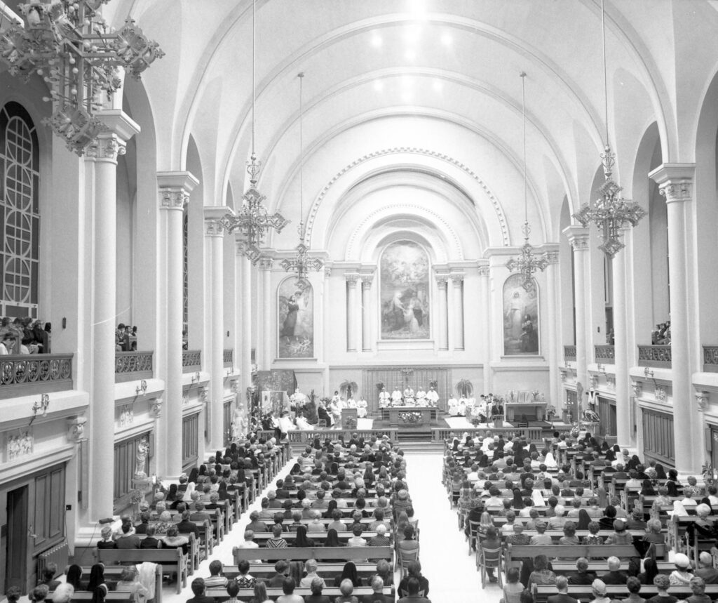 Archival black and white image of a religious ceremony in a Neoclassical chapel.