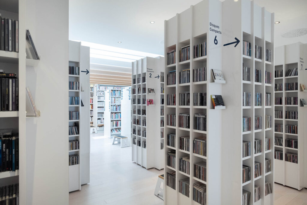 Interior of a contemporary library showing square towers of narrow bookshelves for CDs.