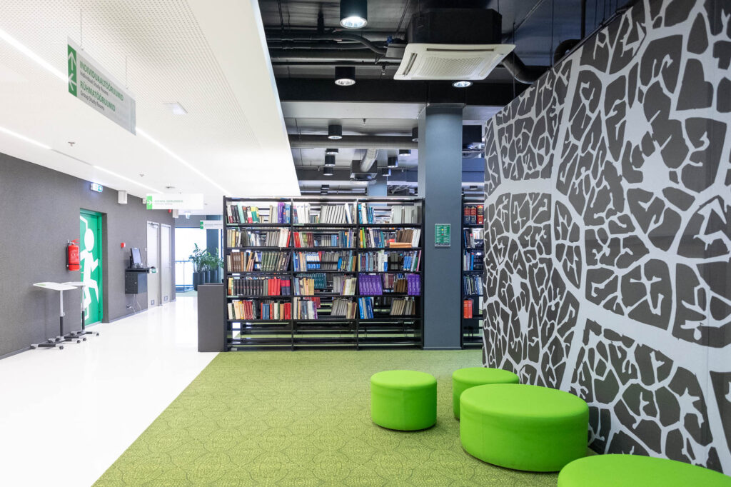 Interior of a contemporary library, showing a wall decorated with a leaf pattern.