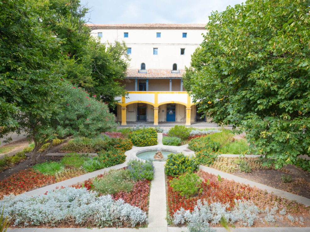 Exterior of a Provençal house fronted by a formal garden.