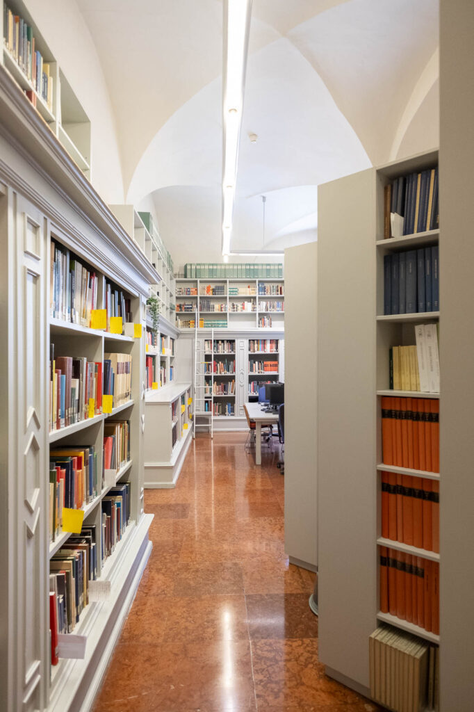 Interior of a library inside a Renaissance palazzo, a vaulted room with high bookshelves.