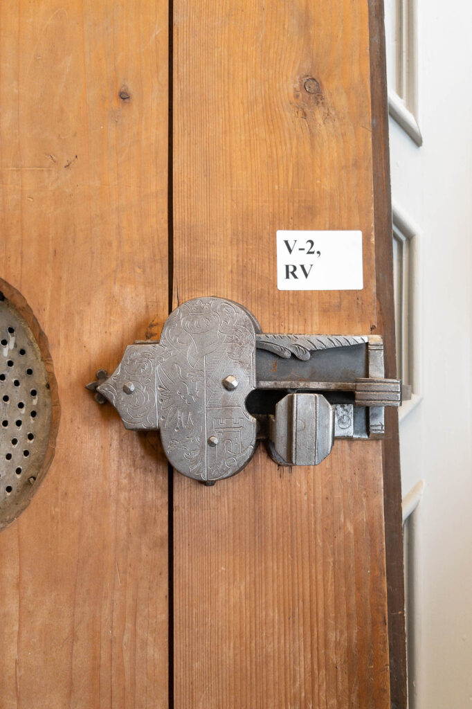 Detail of a Renaissance iron lock on a wooden door, showing decorations inscribed in the metal.